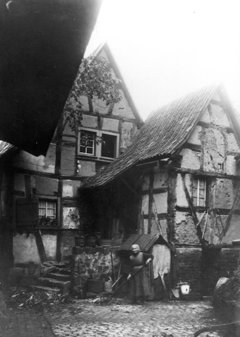 Der Binnenhof und die Nr. 39, davor wohl Frau Margareta Brenig, geb. Mies, die Ehefrau des Urban Brenig, vor der Instandsetzung des Hauses, ca. 1920